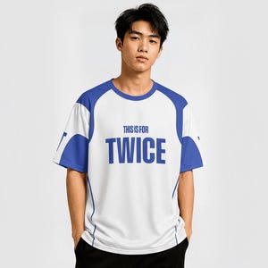 以下が含まれることがあります： 「THIS IS FOR TWICE」の青い文字が入った、白と青の半袖Tシャツ。肩と袖に青いアクセントがあります。黒いズボンを履いている人。