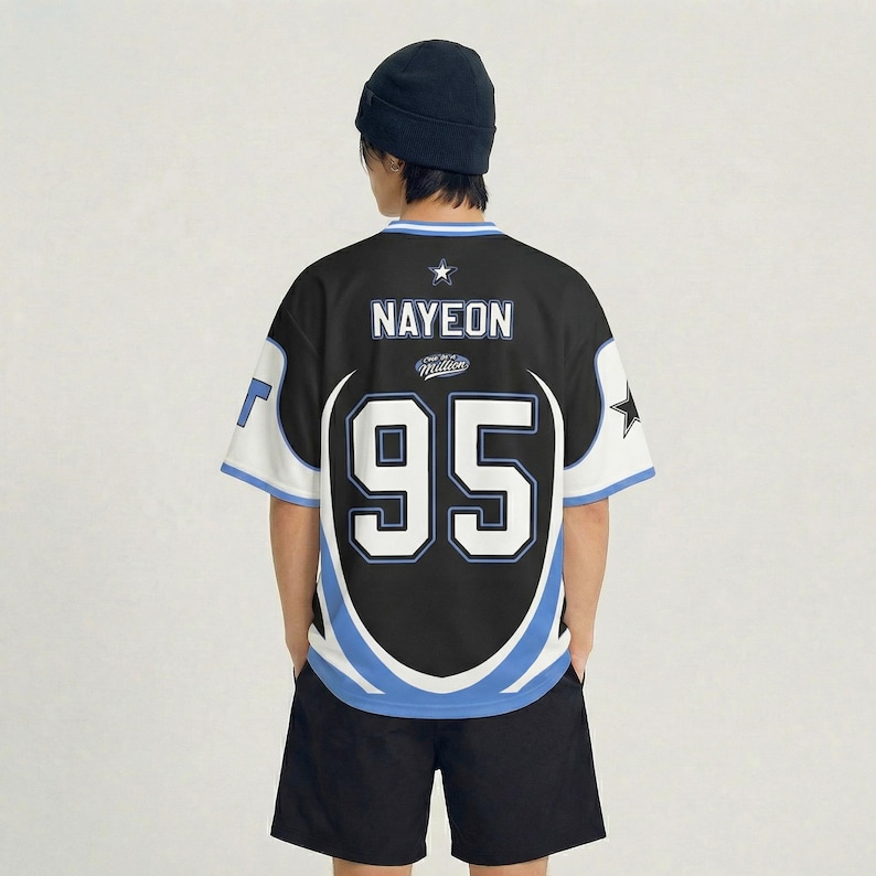 Puede incluir: Camiseta negra y blanca con el nombre "NAYEON" y el n&uacute;mero "95" en la espalda. La camiseta tiene detalles en azul y blanco y un gr&aacute;fico de estrella. La persona lleva un gorro negro y pantalones cortos negros.