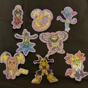 以下が含まれることがあります： 紫色の縁取りが付いた、手描きのカラフルなキャラクターのステッカーのコレクション。ステッカーには、翼のあるヘビ、星型の体を持つ生き物、稲妻の尾を持つ生き物など、ユニークなデザインのさまざまな空想上の生き物が描かれています。