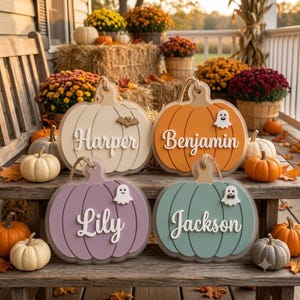 May include: Four decorative wooden pumpkin signs with jute rope hangers. The cream pumpkin says Harper with a bat, the orange says Benjamin with a ghost, the lavender says Lily with a ghost, and the teal says Jackson with a ghost wearing a bow tie.