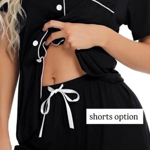 May include: Black pajama set with white trim and buttons. The shorts have a white drawstring. The text "shorts option" is visible in a white box. The top has short sleeves and a chest pocket.