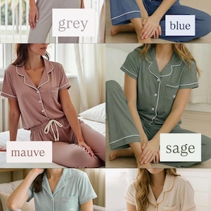 May include: A collection of women's pajama sets in various colors: grey, blue, mauve, sage, green grey, and sand. Each set includes a short-sleeved button-down top and matching pants, all with white piping. The word for each color is displayed in a white box.