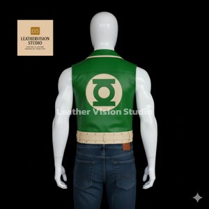 May include: Green leather vest with a cream-colored collar and belt. The back of the vest features a large, circular emblem in cream. The vest is worn over a pair of blue jeans. The text "Leather Vision Studio" is visible.