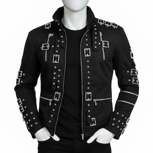 May include: Black jacket featuring numerous silver buckles, zips, and rivets. The jacket, displayed on a mannequin, has a stand-up collar. Sleeves are detailed with multiple buckles and rivets. The jacket is a dark colour.