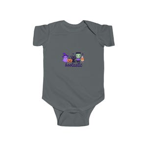 May include: A dark gray short-sleeve baby bodysuit featuring a central graphic of a purple ghost, an orange jack-o'-lantern, a black cat, a green Frankenstein monster, and a piece of candy corn, with the purple text "bootastic" below.