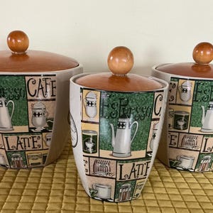 Peut inclure: Une tasse en céramique blanche avec une anse noire et le texte "But First, Coffee" en gras noir. La tasse est posée sur un fond flou. La tasse mesure environ 10 cm de hauteur.