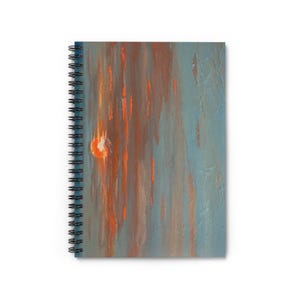 May include: Spiral-bound notebook with an abstract design. The cover features a textured, painted effect with vertical streaks of orange and brown against a blue-gray background. The spiral binding is black.