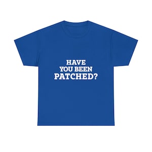 May include: A royal blue t-shirt with the white text "HAVE YOU BEEN PATCHED?" centered on the front. The shirt is a short-sleeved crew neck style, suitable for casual wear. The text is in a bold, sans-serif font.