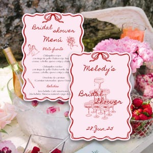 Puede incluir: Dos menús rosas para una despedida de soltera con texto e ilustraciones en rojo. Un menú dice "Bridal Shower Menu" con una lista de alimentos. El otro dice "Melody's Bridal Shower" con la fecha "28. Jun. 25".