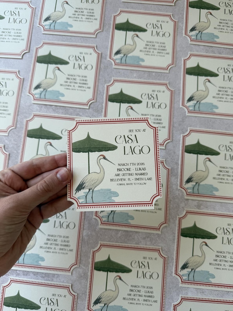 May include: Wedding invitation cards with a Casa Lago theme. Each card features a crane illustration under a green parasol. The cards have a red border and include event details: date, names, and location.