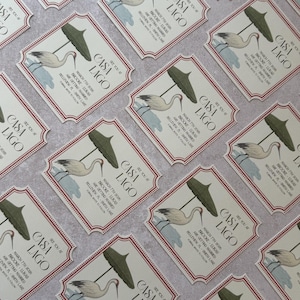 May include: Arrangement of invitation cards with a vintage design. Each card features the text "CASA LAGO" and event details, along with an illustration of a crane and a parasol. The cards have a cream background with a red border.