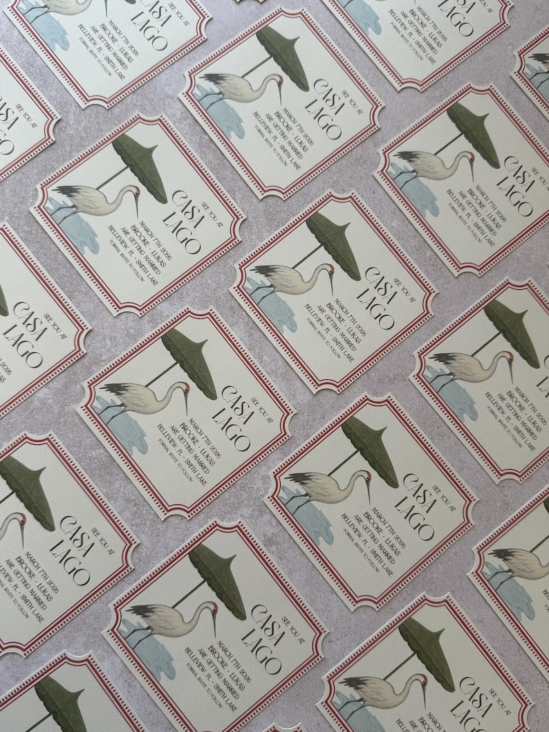 May include: Arrangement of invitation cards with a vintage design. Each card features the text "CASA LAGO" and event details, along with an illustration of a crane and a parasol. The cards have a cream background with a red border.