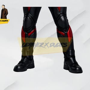 May include: Black leather pants with red accents on the lower legs and knees. The pants have a sleek, form-fitting design and are paired with black boots. The image also includes a logo with two figures and the text "LEATHER X DUDES".