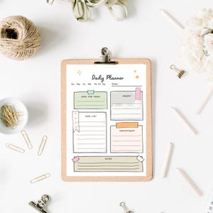 Op de afbeelding: Een klembord met een "Daily Planner"-blad. De planner heeft secties voor doelen, taken, afspraken en notities, met pastelkleurige accenten. De afbeelding bevat potloden, paperclips en decoratieve elementen.