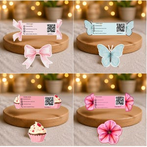 Puede incluir: Cuatro diseños de tarjetas de visita con elementos decorativos. Las tarjetas se muestran en plataformas de madera. Los diseños incluyen lazos rosas, mariposas azules, cupcakes y flores rosas. Cada tarjeta tiene el texto "YOUR LOGO" y un código QR.