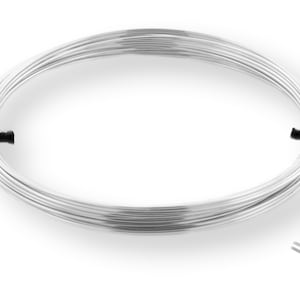 May include: A coil of silver wire, approximately 20 gauge, with a round cross-section. The wire is wrapped around itself and secured with black ties.