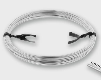 May include: A continuous coil of silver-colored metal wire secured with two black twist ties. The wire has a smooth, reflective surface and a circular cross-section, as indicated by the small graphic labeled Round in the corner.