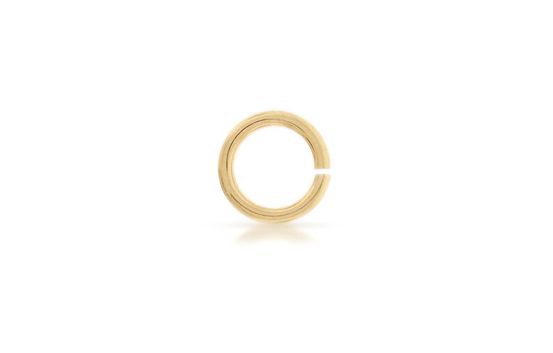 K&ouml;nnte beinhalten: Ein goldener Sprungring, eine Art von Schmuckzubeh&ouml;r, das zum Verbinden von Ketten, Anh&auml;ngern und anderen Schmuckkomponenten verwendet wird.