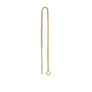 May include: A single gold-colored earring with a chain and a straight post. The chain is made of small, square links, and the post has a small loop at the end. The earring is designed to be pulled through the ear.