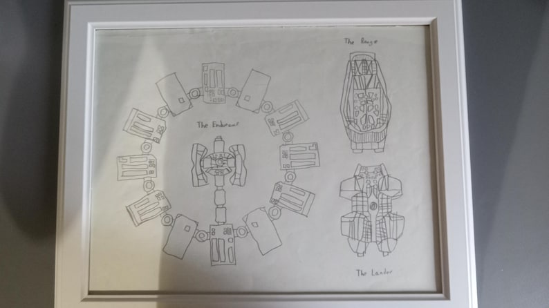 May include: Framed pencil sketch of a spacecraft design, featuring detailed diagrams labeled "The Endurance," "The Ranger," and "The Lander." The artwork is encased in a white frame, showcasing the technical drawings.