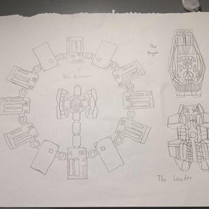 May include: A pencil sketch of a space station and two spacecraft. The space station is circular with rectangular modules. The spacecraft are labeled "The Ranger" and "The Lander".