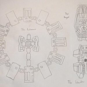 May include: A hand-drawn sketch of spacecraft designs. The Endurance, a circular space station, is depicted alongside The Ranger and The Lander. The Endurance is labeled, and the other two spacecraft are also labeled.