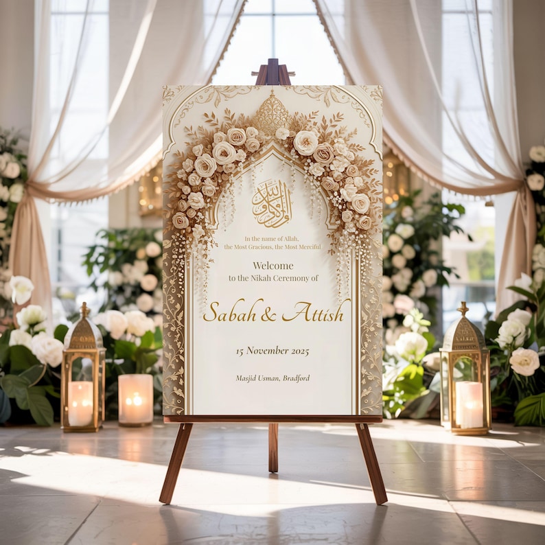 Nikah welcome sign with gold floral arch on wooden easel in a decorated indoor garden-style wedding hall.