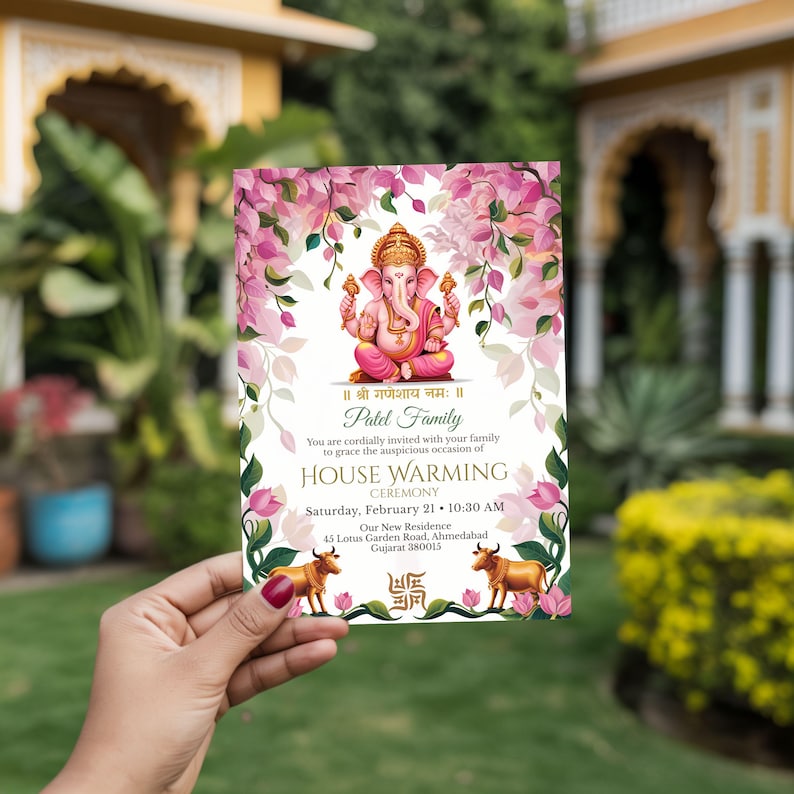 Handheld Hindu house warming invitation featuring Lord Ganesha, pink floral border and gold details, traditional griha pravesh ceremony card