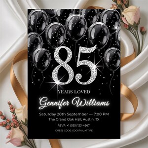 Puede incluir: Invitación de cumpleaños número 85 en blanco y negro con detalles plateados brillantes. El diseño presenta globos negros, el número 85 en fuente de diamantes y detalles del evento. El texto incluye "Years Loved" y el nombre "Gennifer Williams".