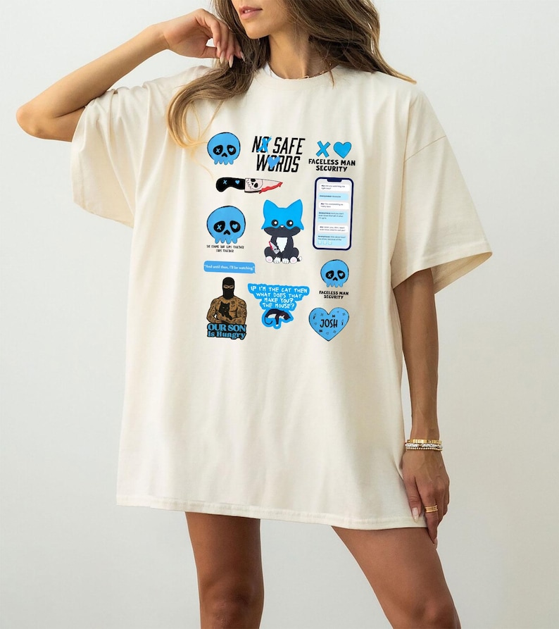 Puede incluir: Camiseta de gran tama&ntilde;o de color crema con varios dise&ntilde;os gr&aacute;ficos azules y negros. Los gr&aacute;ficos incluyen calaveras, un cuchillo, un zorro y texto que dice "NO SAFE WORDS", "FACELESS MAN SECURITY" y "OUR SON IS HUNGRY".