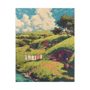 May include: A completed jigsaw puzzle featuring a whimsical illustration of hobbit homes nestled into green hills. The scene includes a blue sky with fluffy clouds, a stream, and a clothesline with hanging laundry. A barrel sits near a wooden house.