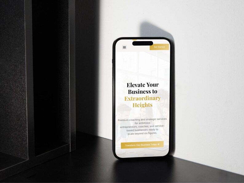 Pu&ograve; includere: Uno smartphone nero mostra un sito web con il testo "Elevate Your Business to Extraordinary Heights". Il telefono &egrave; posizionato su una superficie scura accanto a una struttura nera, con un muro bianco sullo sfondo. Il sito offre servizi di coaching.