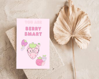 May include: A pink greeting card with the text "YOU ARE BERRY SMART" and illustrations of strawberries and raspberries. The card is on a stone block with a dried palm leaf in the background. The shop name "CYCY'S WONDERLAND" is at the bottom.