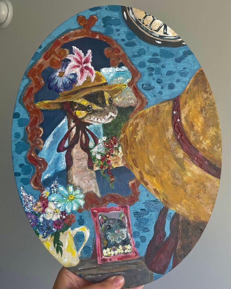 May include: Oval painting of a snake in a hat looking in a mirror. The mirror shows the snake wearing a hat and flowers. A yellow jug with flowers and a framed picture of a cat are also in the painting.