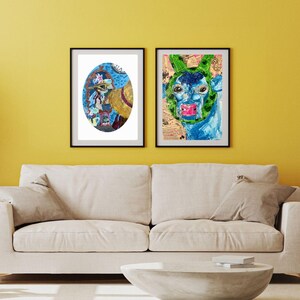 May include: Two framed abstract art prints. One features a blue and yellow oval design with floral and face elements. The other depicts a blue and green face with a green head covering and pink lips. Both are in black frames.