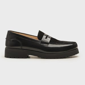 K&ouml;nnte beinhalten: Schwarzer Leder-Loafer mit klobiger Sohle. Der Schuh hat einen Veloursleder-Einsatz am Blatt und ein gl&auml;nzendes Finish. Die Sohle ist etwa 3,8 cm hoch.