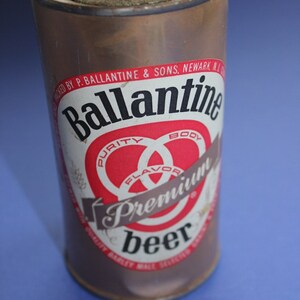 Könnte beinhalten: Eine Vintage-Aluminiumdose Ballantine Premium Bier. Die Dose ist braun mit einem rot-weiß-schwarzen Etikett mit dem Ballantine-Logo und den Worten "Reinheit, Geschmack, Körper".