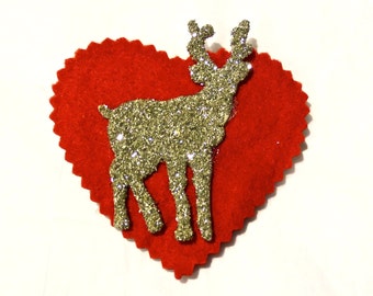 May include: A red felt heart with a gold glitter reindeer cutout. The reindeer is facing right and has antlers.