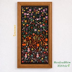 Könnte beinhalten: Ein gerahmtes Kreuzstich-Kunstwerk mit schwarzem Hintergrund, das die vier Jahreszeiten darstellt. Das Kunstwerk zeigt bunte Blumen, Vögel, Kürbisse, Schneemänner und andere saisonale Elemente. Der Rahmen ist aus Holz, und der Text "Seasons" befindet sich auf der linken Seite.