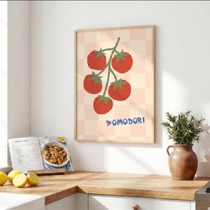 Peut inclure: Une affiche murale rectangulaire dans un cadre en bois clair représentant une grappe de cinq tomates rouges avec des tiges vertes sur un fond à carreaux rose pâle et crème, avec le texte bleu POMODORI imprimé sous les tomates.