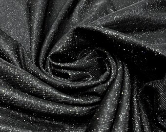 May include: Close-up of black fabric with a shimmering, glittery texture. The material is draped and swirled, creating folds and shadows that highlight the sparkling details. The fabric appears soft and luxurious.