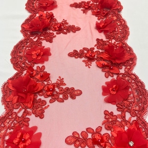 May include: Red lace table runner with floral and sequin embellishments. The runner features 3D fabric flowers and intricate lace edging. The delicate design is suitable for weddings, parties, or home decor.