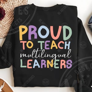 May include: Black sweatshirt with the text "PROUD TO TEACH multilingual LEARNERS" in colorful block letters. The design features a mix of yellow, purple, blue, orange, green, and white text, perfect for educators.
