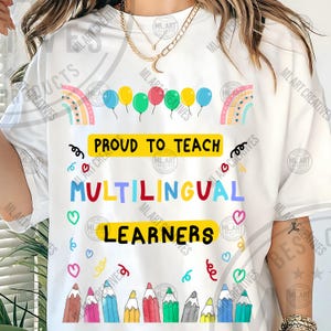 Könnte beinhalten: Weißes T-Shirt mit dem Text "PROUD TO TEACH MULTILINGUAL LEARNERS". Das Design umfasst bunte Ballons, Regenbogen, Herzen und Bleistifte. Ein Geschenk für Lehrer.