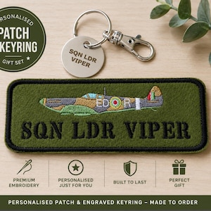 May include: An olive green rectangular embroidered patch featuring a stitched aeroplane graphic and the text SQN LDR VIPER in black thread. A circular silver metal keyring is attached, engraved with the text SQN LDR VIPER on its surface.