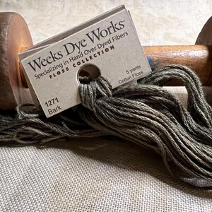 May include: A skein of Weeks Dye Works hand-dyed cotton floss in the color "Bark" (1271). The floss is wound on a wooden spool and is 5 yards long.