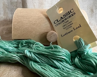 May include: A skein of light green embroidery floss in a wooden box with a label that reads "CLASSIC COLORWORKS 5 Yards 100% Cotton Not Colorfast CCT-020 Lettuce Leaf"