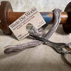 May include: A spool of light brown embroidery floss with a label that reads "Weeks Dye Works" and "1150 Spanish Moss". The label also states "Specializing in Hand Over Dyed Fibers" and "Floss Collection".