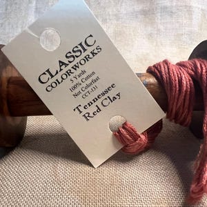 May include: A spool of red clay colored embroidery floss, 5 yards long, 100% cotton, not colorfast, labeled "Classic Colorworks CCT-131 Tennessee Red Clay"