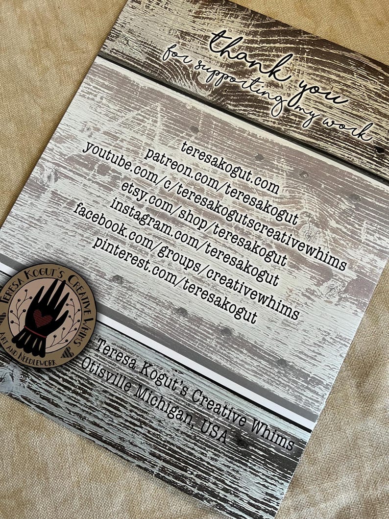 May include: A thank you card with a rustic woodgrain background. The card features the text "thank you for supporting my work" and a list of social media handles and websites for Teresa Kogut's Creative Whims. The card also includes the text "Teresa Kogut's Creative Whims Otisville Michigan, USA".